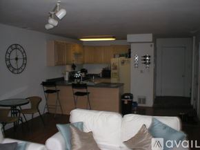 Chicago house for rent - A kitchen with a white couch and a clock on the wall.