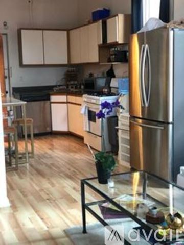 Chicago apartment for rent - A kitchen with a stainless steel refrigerator and wooden floors.