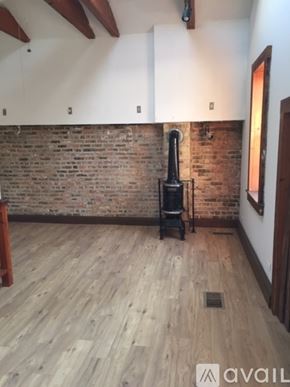 Chicago apartment for rent - A room with a wood floor and a brick wall.