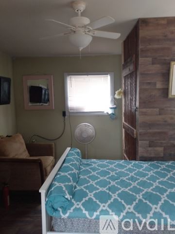 Ronda house for rent - A bedroom with a bed, a couch, a ceiling fan, and a window with blinds.