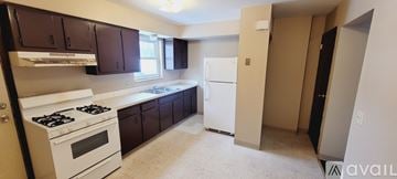 Canton townhouse for rent - A kitchen with white appliances and dark brown cabinets.