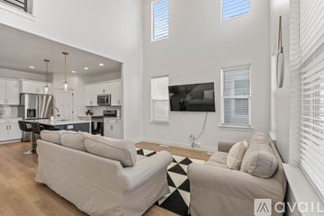 Lehi apartment for rent - A modern living room with a large couch and a kitchen area in the background.