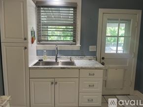 Nashville house for rent - A kitchen with a sink and cabinets under a window.