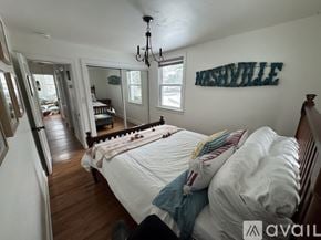 Nashville house for rent - A bedroom with a bed and a chandelier.