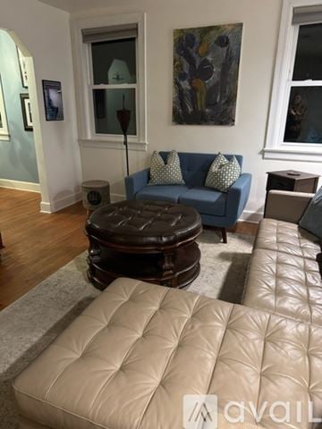 Nashville house for rent - A living room with a blue couch and a brown ottoman.