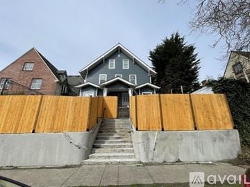 Seattle apartment for rent - A house with a grey roof and a wooden fence in front.