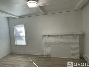 Seattle apartment for rent - A room with a white brick fireplace and wooden flooring.