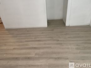 Seattle apartment for rent - A room with a wooden floor and white walls.