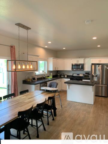 Vineyard apartment for rent - A modern kitchen with wooden chairs and a wooden table.