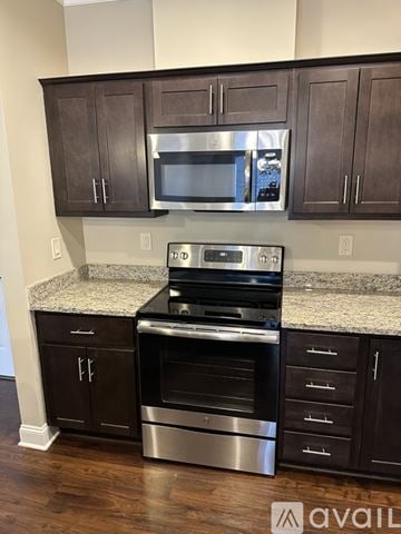 New Hartford apartment for rent - A kitchen with dark brown cabinets and stainless steel appliances.