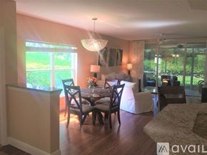 Naples condo for rent - A dining room with a table set for four and a chandelier hanging from the ceiling.