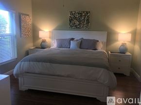 Naples condo for rent - A bedroom with a large bed, two nightstands with lamps, and a floral picture on the wall.
