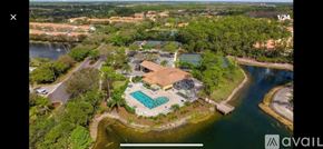 Naples condo for rent - A bird's eye view of a house with a swimming pool surrounded by a forested area.