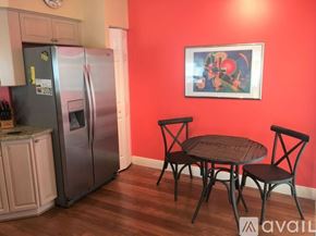 Naples condo for rent - A kitchen with a refrigerator, table and chairs.