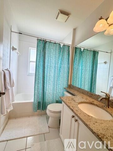 Naples condo for rent - A living room with a glass table and chairs, a ceiling fan, and a large window with blinds.