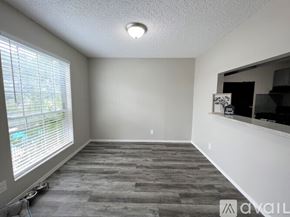 Victoria apartment for rent - A room with a grey floor and a window with blinds.