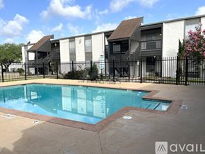 Victoria apartment for rent - A swimming pool surrounded by a black fence and a building in the background.