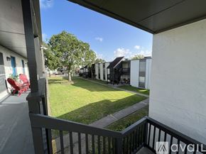 Victoria apartment for rent - A balcony view of a grassy area with trees and a row of houses.