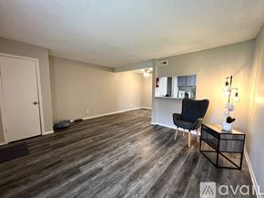 Victoria apartment for rent - A room with a black chair and a wooden floor.