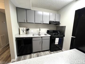 Victoria apartment for rent - A kitchen with black appliances and white cabinets.