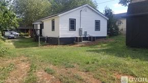 Greenville house for rent - A small white house with a black door and a black awning.