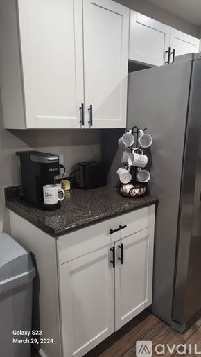 Greenville house for rent - A kitchen with white cabinets and a black refrigerator.