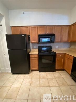West Palm Beach condo for rent - A kitchen with black appliances and wooden cabinets.