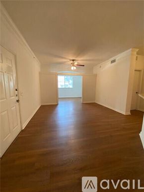 West Palm Beach condo for rent - A long hallway with wooden floors and white walls.