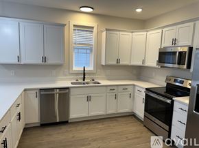 Rome townhouse for rent - A kitchen with white cabinets and stainless steel appliances.
