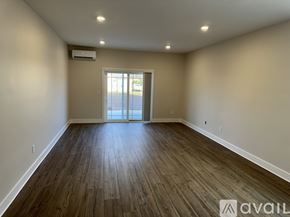 Rome townhouse for rent - A spacious room with wooden flooring and a sliding glass door.