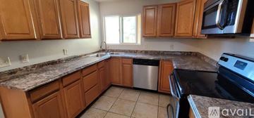 Palm Desert house for rent - A kitchen with wooden cabinets and granite countertops.