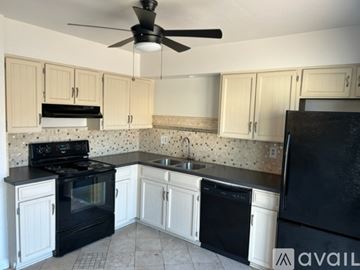 Tempe house for rent - A kitchen with black appliances and white cabinets.