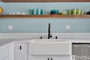 El Segundo apartment for rent - A kitchen with a white sink and a wooden shelf above it.