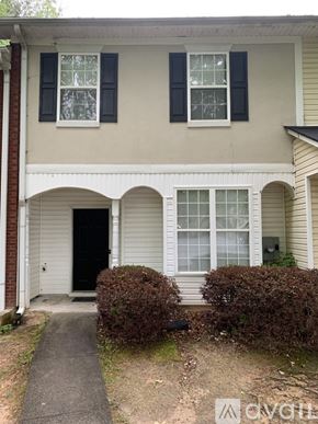 Riverdale house for rent - A beige house with black shutters and a black door.