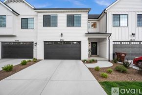 Midvale townhouse for rent - A white house with a black garage door is numbered 6799.