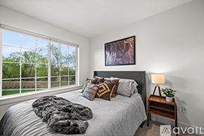 Midvale townhouse for rent - A bedroom with a large bed and a window overlooking a green area.