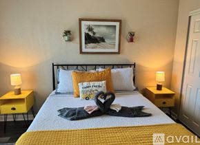 Gulfport apartment for rent - A bedroom with a bed, two lamps, and a picture on the wall.