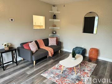 Gulfport apartment for rent - A living room with a grey couch, a white coffee table, and a rug with a floral pattern.