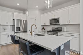 Lehi apartment for rent - A kitchen with white cabinets and a large island.