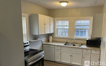 Shaker Heights apartment for rent - A kitchen with white cabinets and a black stove top.