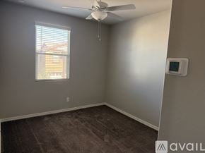 Gilbert apartment for rent - A room with a ceiling fan and a window with blinds.