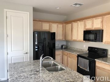Gilbert apartment for rent - A kitchen with granite countertops and wooden cabinets.