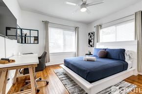Miami apartment for rent - A bedroom with a blue bed and a white desk.