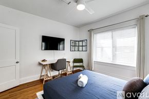 Miami apartment for rent - A bedroom with a bed, desk, chair, and window.