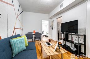 Miami apartment for rent - A living room with a blue couch, a wooden coffee table, and a television.