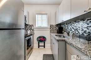 Miami apartment for rent - A kitchen with a stainless steel refrigerator and a black and white tiled backsplash.
