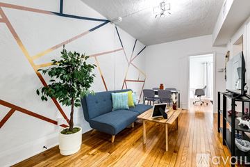 Miami apartment for rent - A living room with a blue couch and a potted plant.