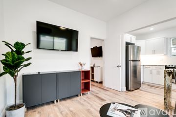 Miami apartment for rent - A living room with a tv on the wall and a plant in a pot.