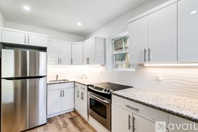 Miami apartment for rent - A modern kitchen with a stainless steel refrigerator and a granite countertop.