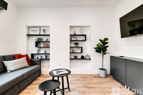 Miami apartment for rent - A living room with a grey couch, a black table, and a TV mounted on the wall.